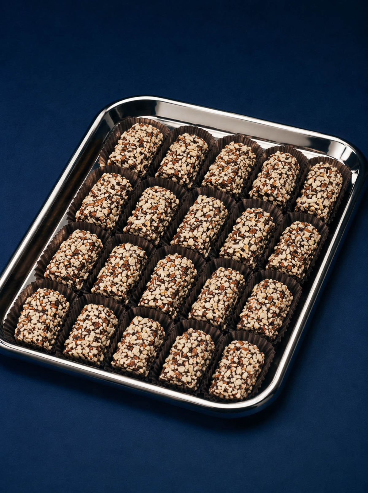 A tray of chocolate-covered english toffee with gourmet dark chocolate and chopped almonds presented in a beautiful tray by Compartes Chocolates Los Angeles.