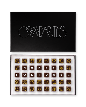 Compartes best Christmas chocolate gift box, dark squares spelling happy holidays among gold flecked pieces, salted caramel