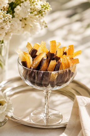 Gourmet Chocolate Covered Orange Rinds and Orange Peels by Compartes Chocolatier Los Angeles in a glass dish.
