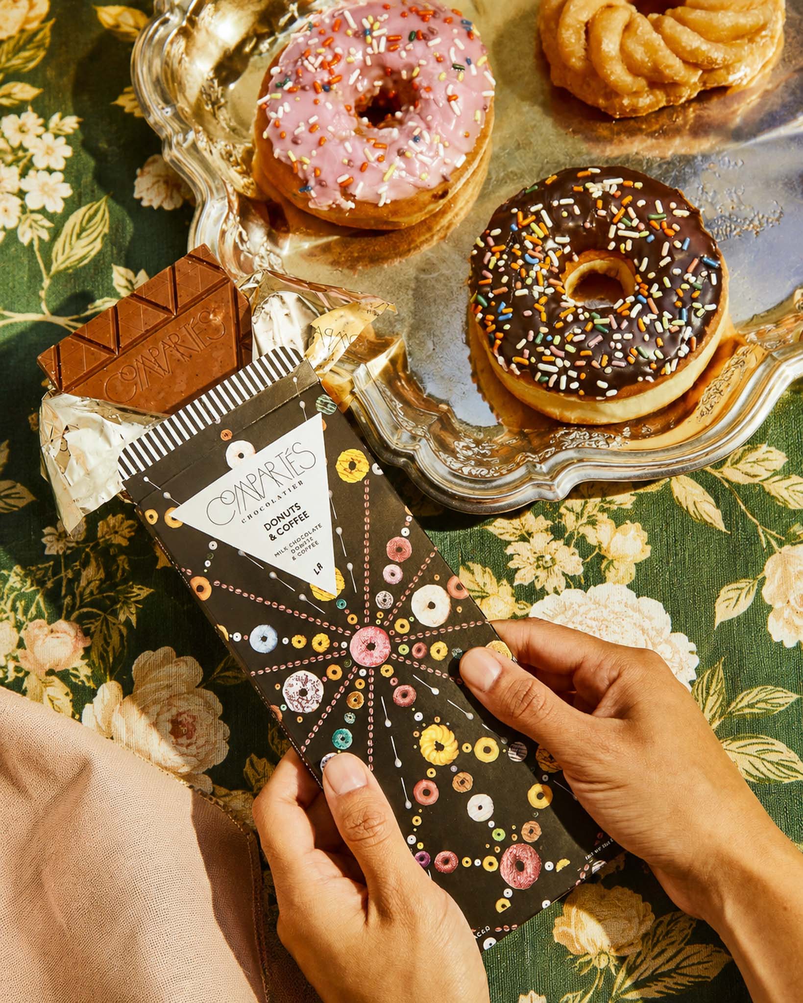 Compartes Donut and Coffee Chocolate Bar made with gourmet donuts and premium milk chocolate plus coffee. Shown on a Los Angeles luxury tablescape with fancy chocolate bars and colorful donuts. 