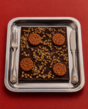 Christmas Chocolate Gingerbread Bark with Gingerbread cookies studded on vegan dark chocolate on a silver plate by Compartes Chocolatier Los Angeles.