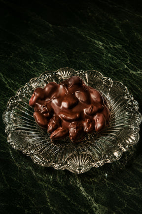 Vegan Dark Chocolate Almonds Bark Handmade in Los Angeles by Compartes Chocolates on a glass plate.