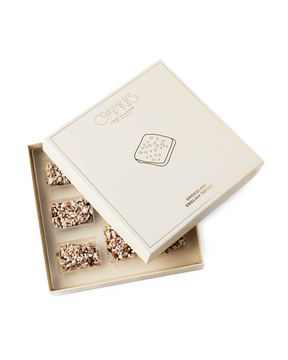 Compartes best chocolate covered english toffee gift box, cream and gold lid set at an angle, almond