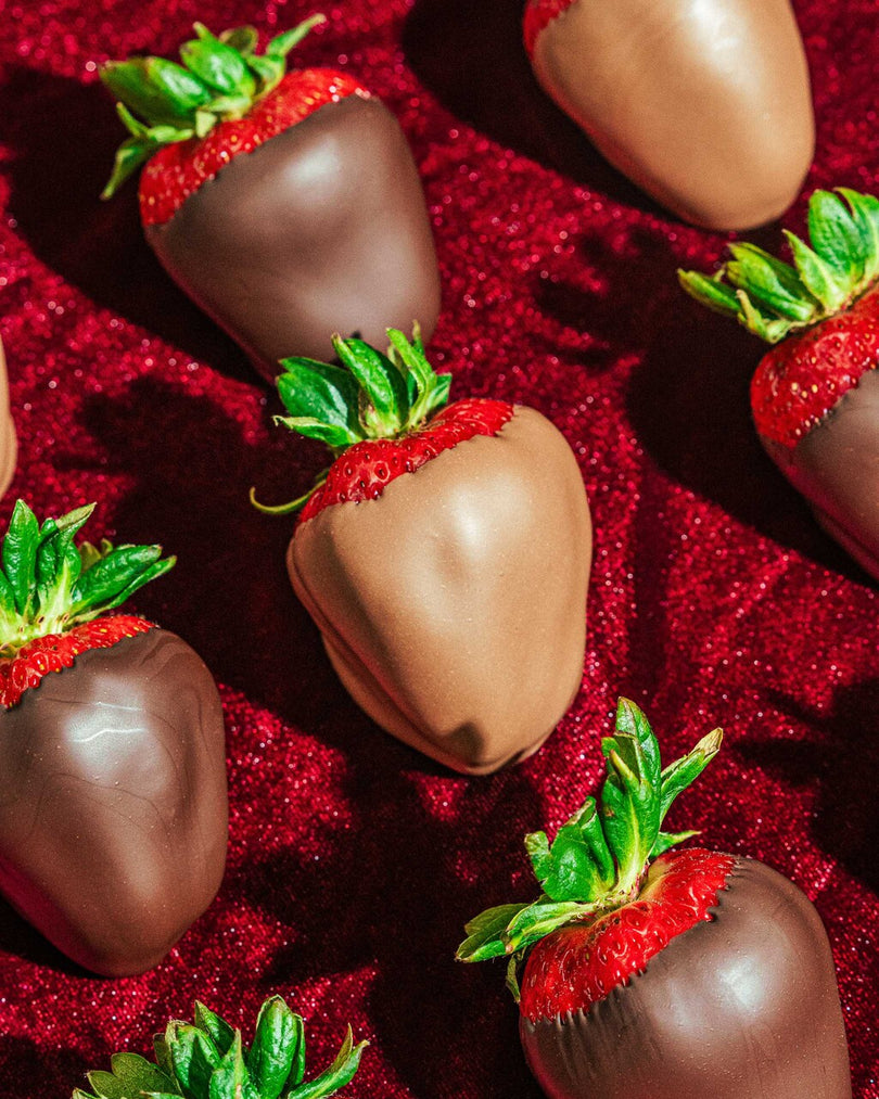Many dark and milk chocolate-covered strawberries.