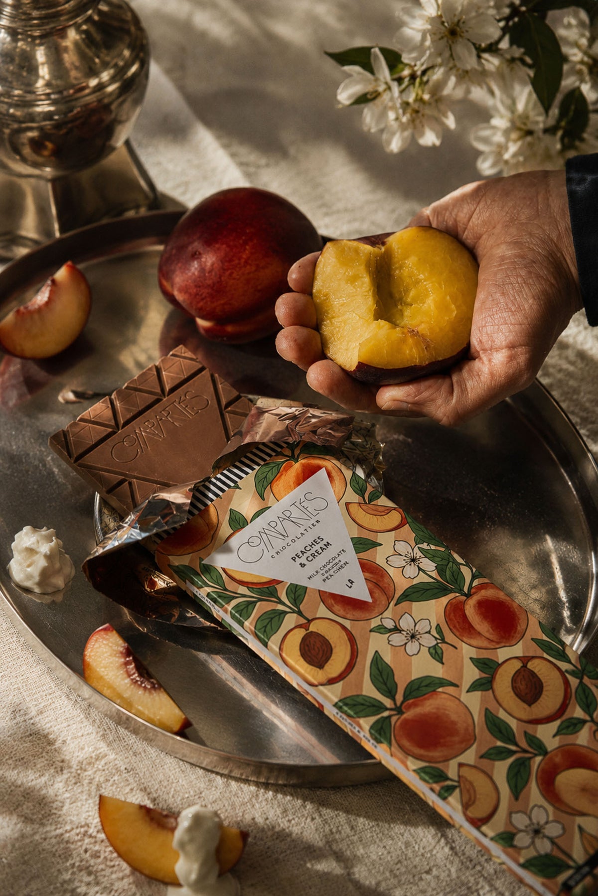 Peaches and Cream Gourmet Fancy Chocolate Bar in a tray with fresh farmers market peaches by Compartes Chocolatier.