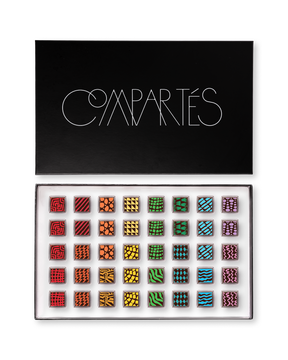 Compartes luxury signature chocolate truffles in a black gift box, squares in rich red, gold and green patterns